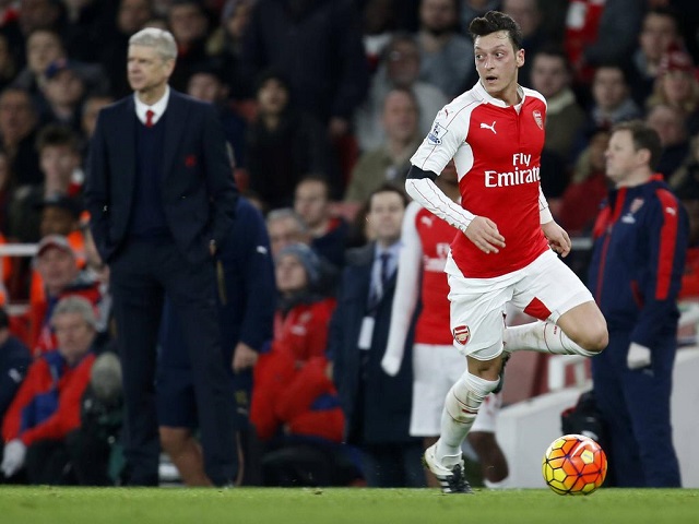 ArsenalÖs Mesut Ozil runs past Arsenal manager Arsene Wenger during the Barclays Premier League matc