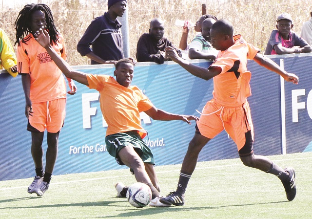Fox player Nqobile Moyo tackles Bulawayo Artists' Shylock Ndlovu while his partner Ralph Malingwa keeps a close eye in a match played in Gwabalanda yesterday