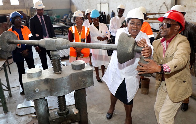 Deputy Minister of Industry and Commerce Chiratidzo Mabuwa yesterday assists White Site Engineering, Engineer David Mwatseteza in demonstrating how one of the machines work during a tour of the company in Bulawayo. — Picture by Eliah Saushoma