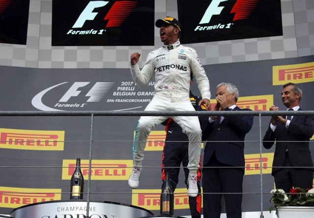 Mercedes driver Lewis Hamilton of Britain, center, jubilates on the podium after winning the Belgian Formula One Grand Prix in Spa-Francorchamps, Belgium