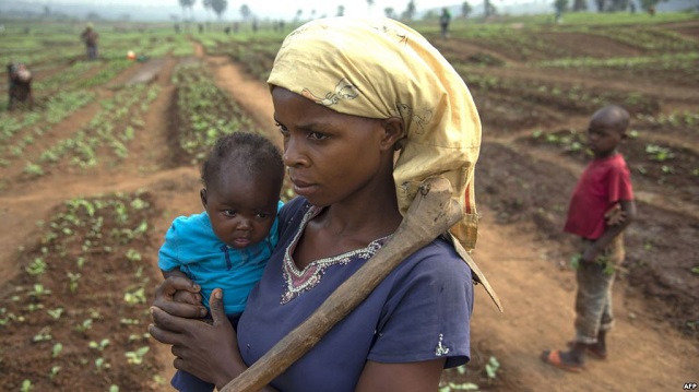 FILE - A woman and her child, who fled from rebel attacks, stand in a field, in Tshikapa, Kasai Region, Democratic Republic of Congo, July 27, 2017