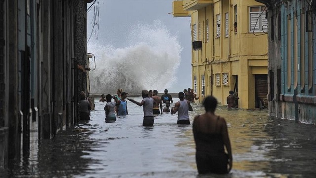 Cubans make their way through a flooded Havanna street recently