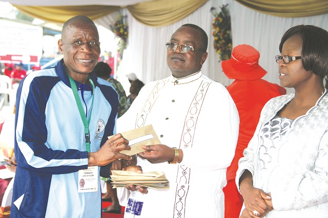 Jairos Jiri Kadoma sports director, Tawanda Chipwanya (left) receives prize money from acting permanent secretary in the Ministry of Sport and Recreation, Benson Dube while the director of sport promotion and development in the Ministry, Eugenia Chidhakwa looks on at Danhiko yesterday