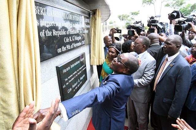 President Mugabe unveils a plaque to mark the official renaming of the Harare International Airport to Robert Gabriel Mugabe International Airport in his honour in Harare yesterday. Flanking him is Transport and Infrastructural Development Minister Dr Joram Gumbo. - (Picture by Presidential Photographer Joseph Nyadzayo)