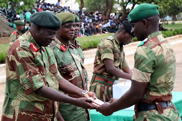 1 Infantry Brigade Commander Brigadier-General Augustine Chipwere (left) presents a shield to one of the best students Jabulani Ncube during a joint pass-out parade at the Zimbabwe School of Infantry in Mbalabala yesterday. Looking on is the commandant of the school Colonel Posani Masaka