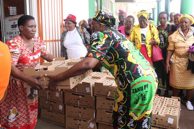 National Women's League vice treasurer Cde Magarine Khumalo (left) hands over chicks to women in Gwanda yesterday